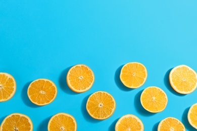 Slices of delicious oranges on light blue background, flat lay. Space for text