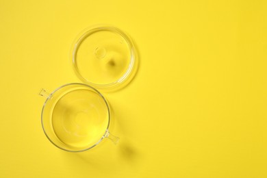 Photo of Empty glass pot and lid on yellow background, flat lay. Space for text