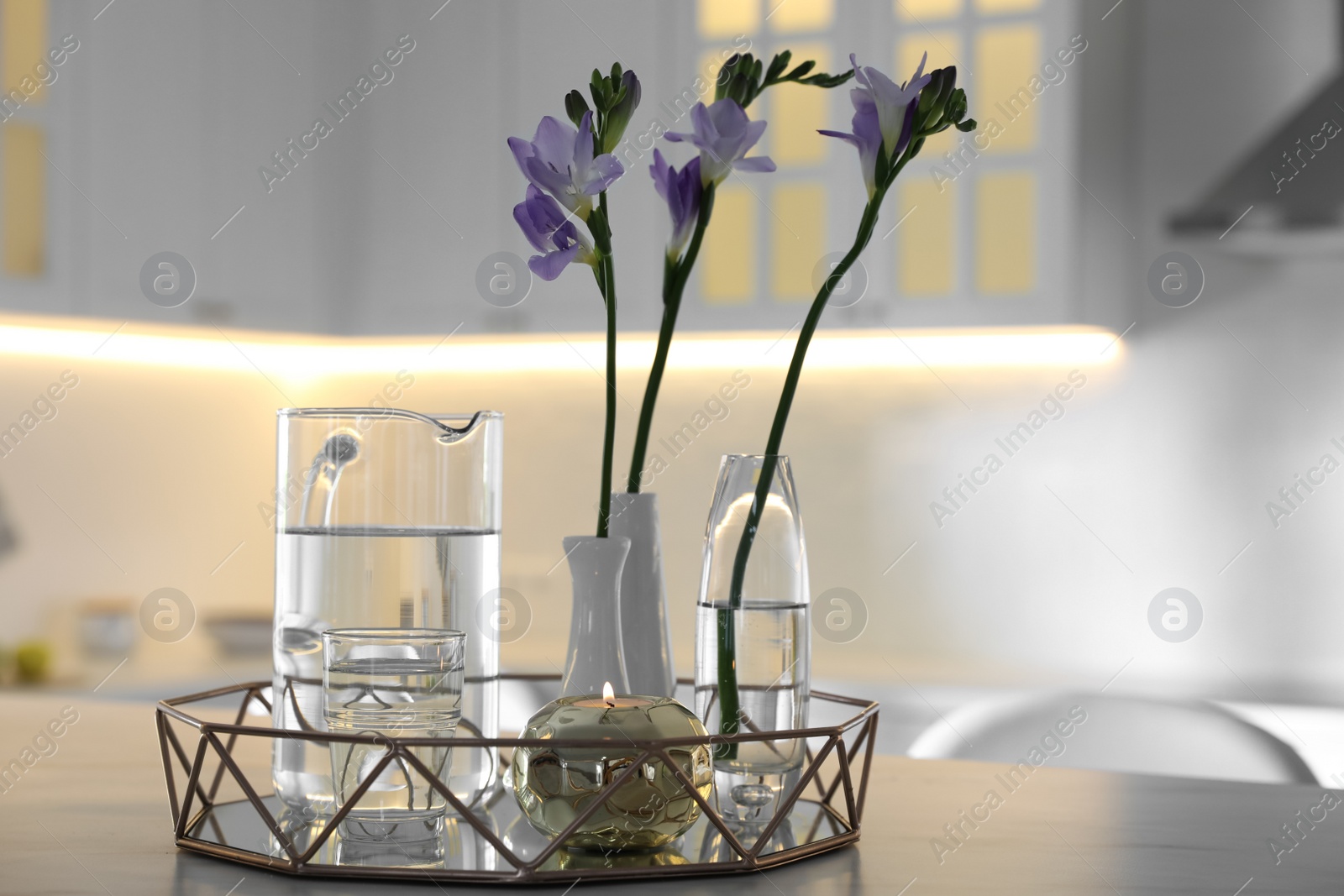 Photo of Beautiful spring freesia flowers on table in kitchen