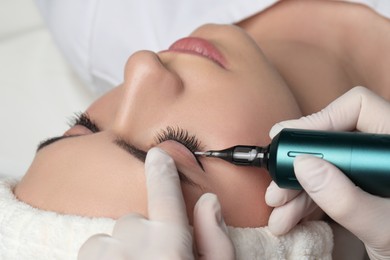 Young woman undergoing procedure of permanent eye makeup, closeup