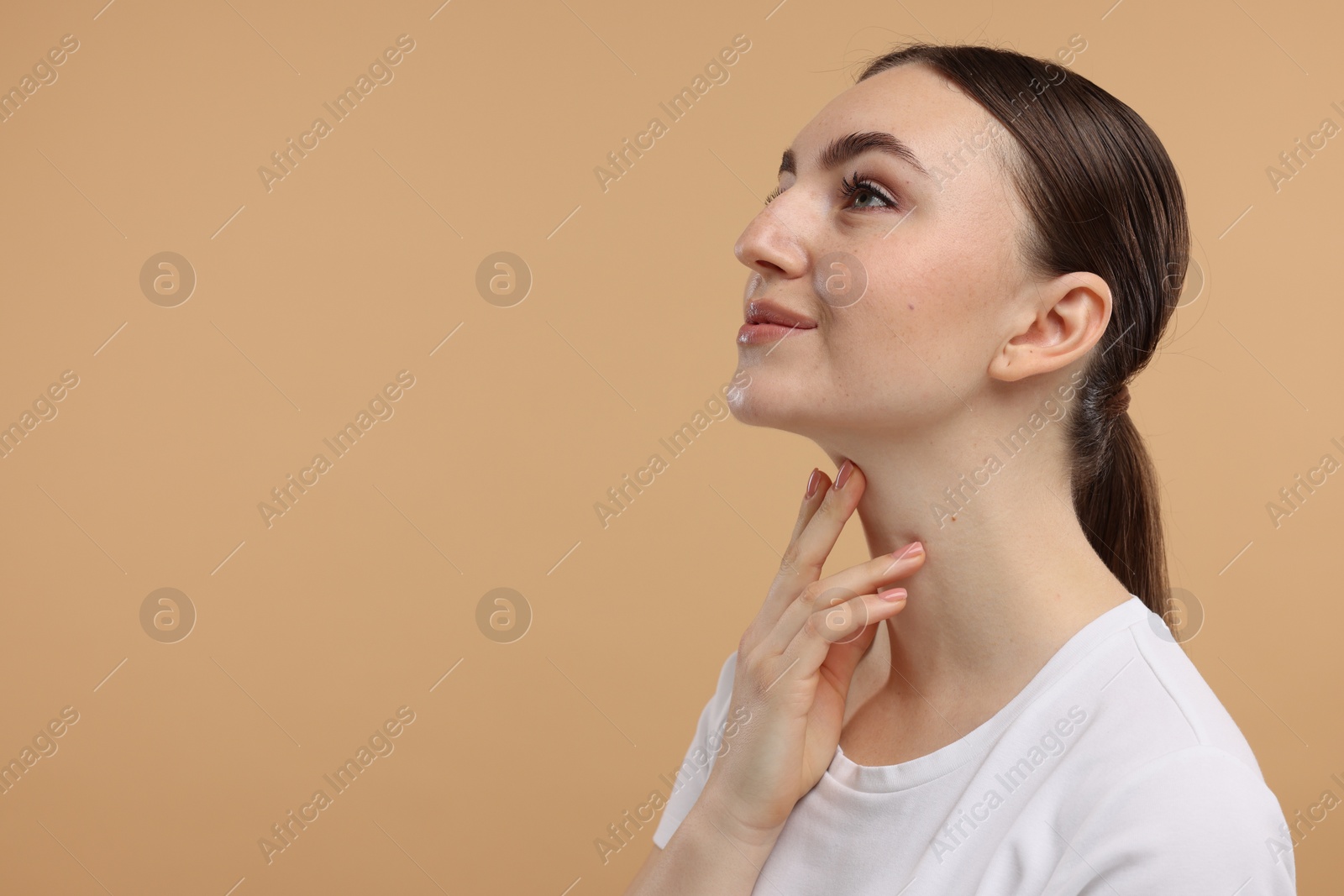 Photo of Beautiful woman touching her chin on beige background. Space for text