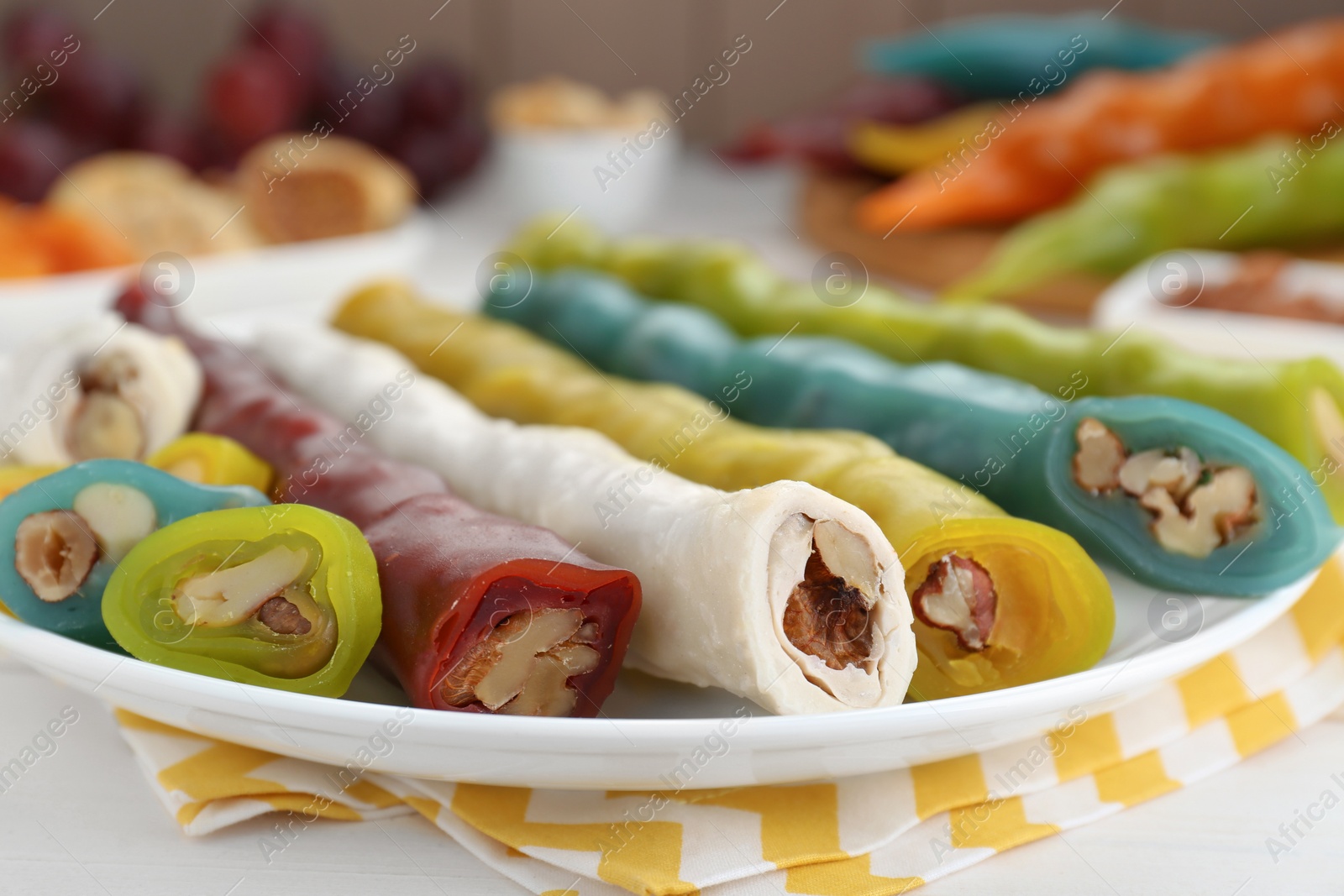 Photo of Delicious sweet churchkhelas on white wooden table, closeup