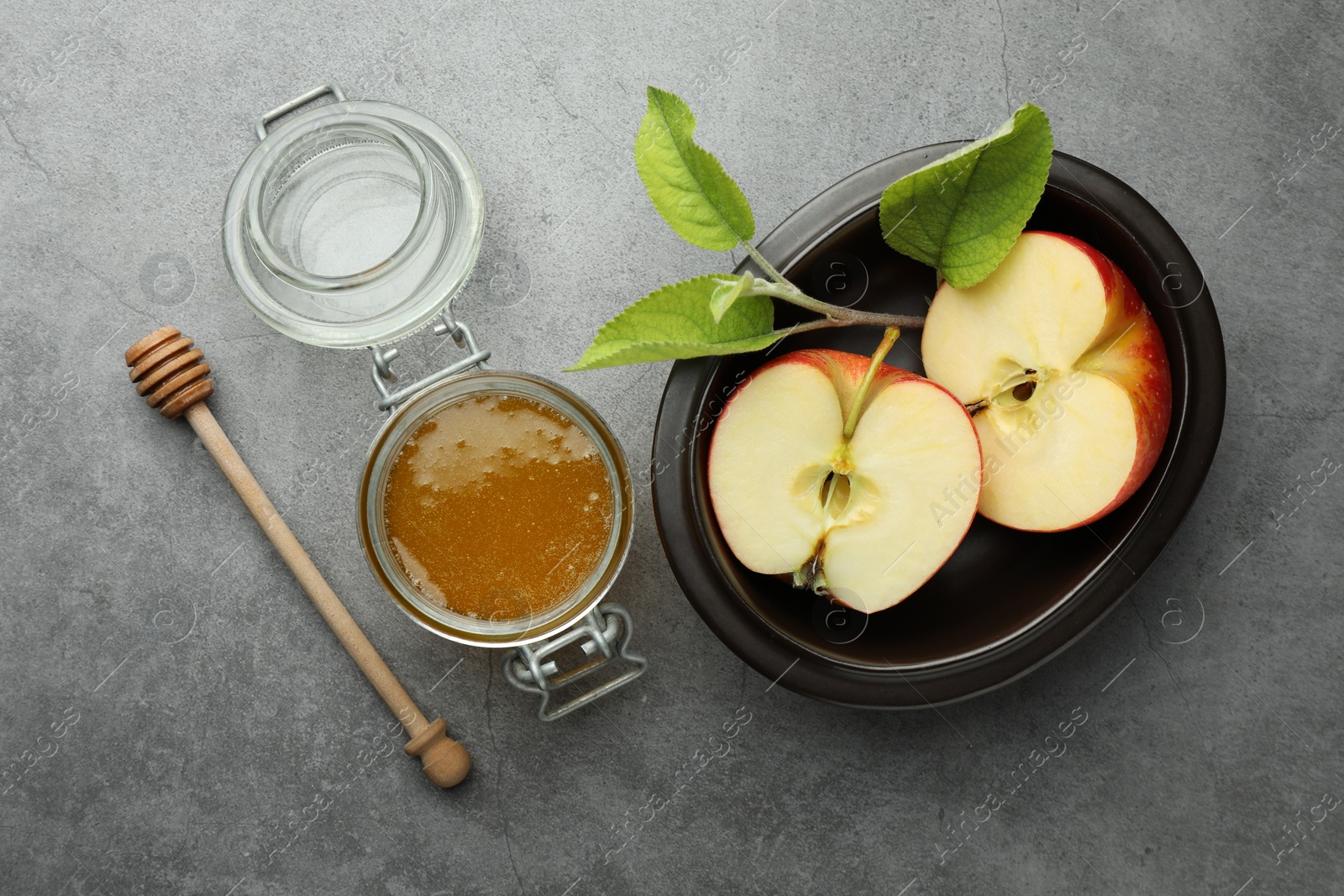 Photo of Sweet honey and fresh apple on grey table, flat lay