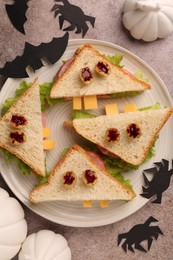 Photo of Tasty monster sandwiches and Halloween decorations on grey textured table, flat lay