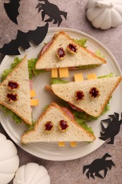 Tasty monster sandwiches and Halloween decorations on grey textured table, flat lay