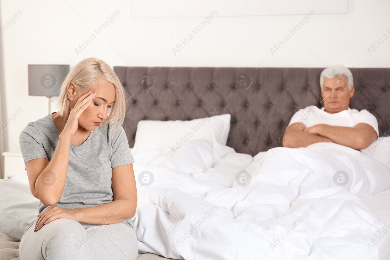 Photo of Senior woman having conflict with her husband in bedroom. Relationship problems