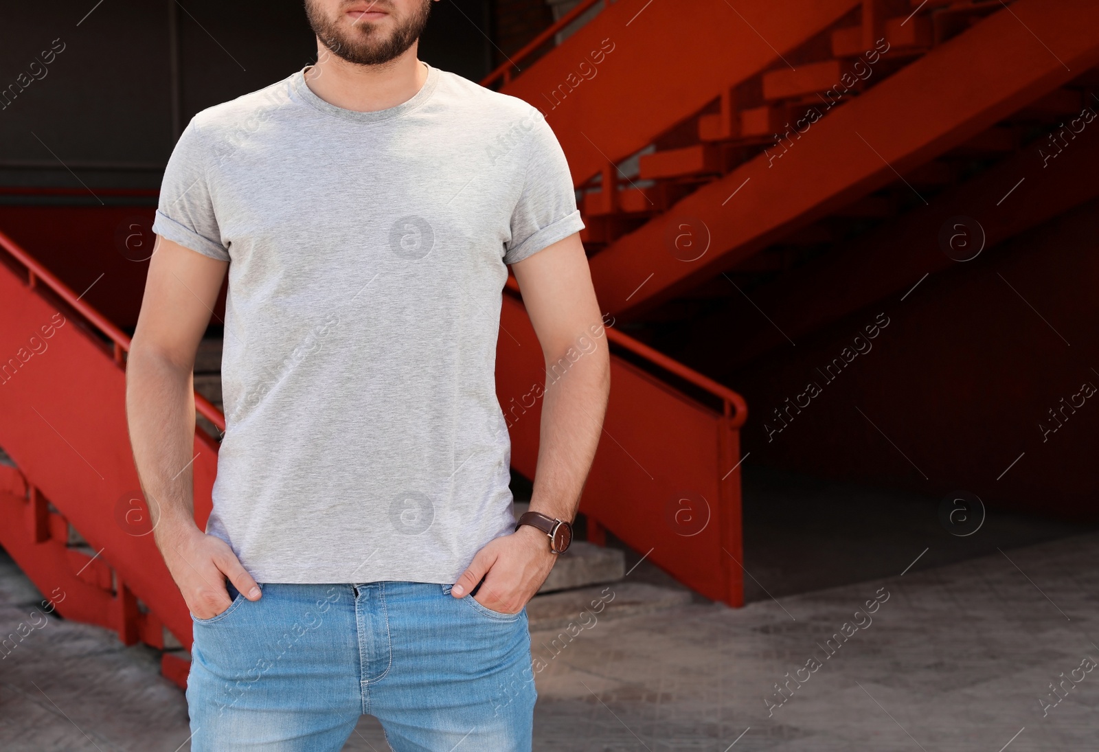 Photo of Young man wearing gray t-shirt on street. Urban style