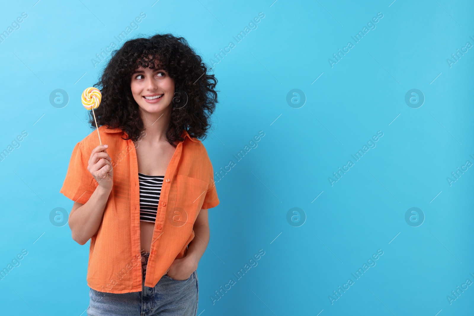 Photo of Beautiful woman with lollipop on light blue background, space for text