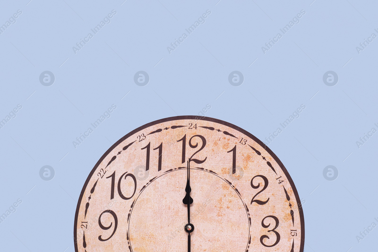 Photo of Stylish round clock on light blue background, top view with space for text. Interior element