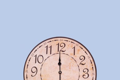 Photo of Stylish round clock on light blue background, top view with space for text. Interior element