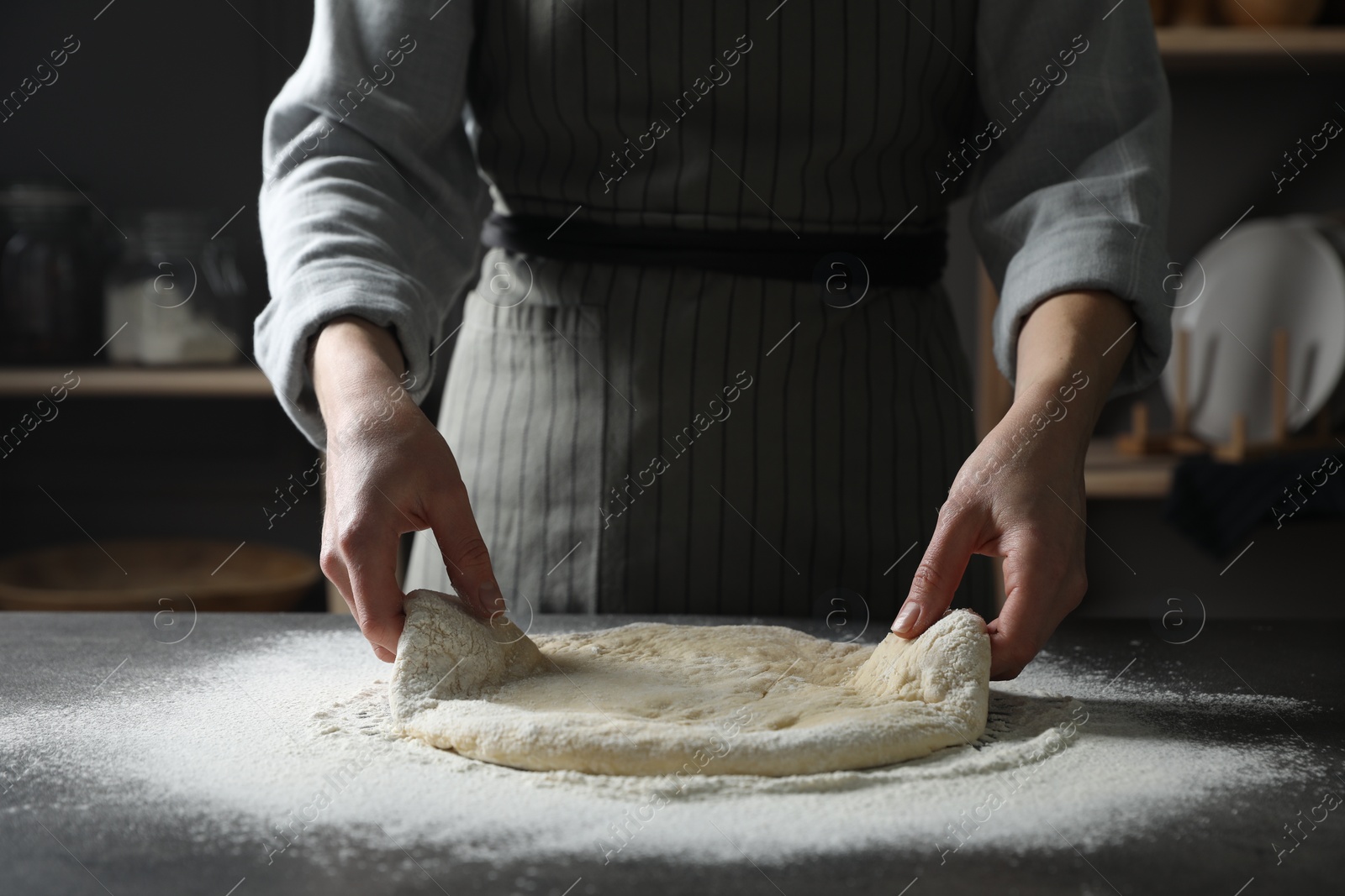 Photo of Woman making pizza dough at table, closeup