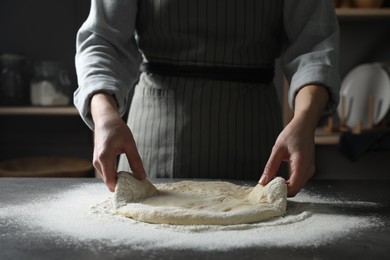 Photo of Woman making pizza dough at table, closeup