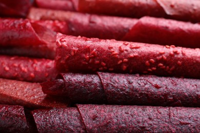 Delicious fruit leather rolls as background, closeup