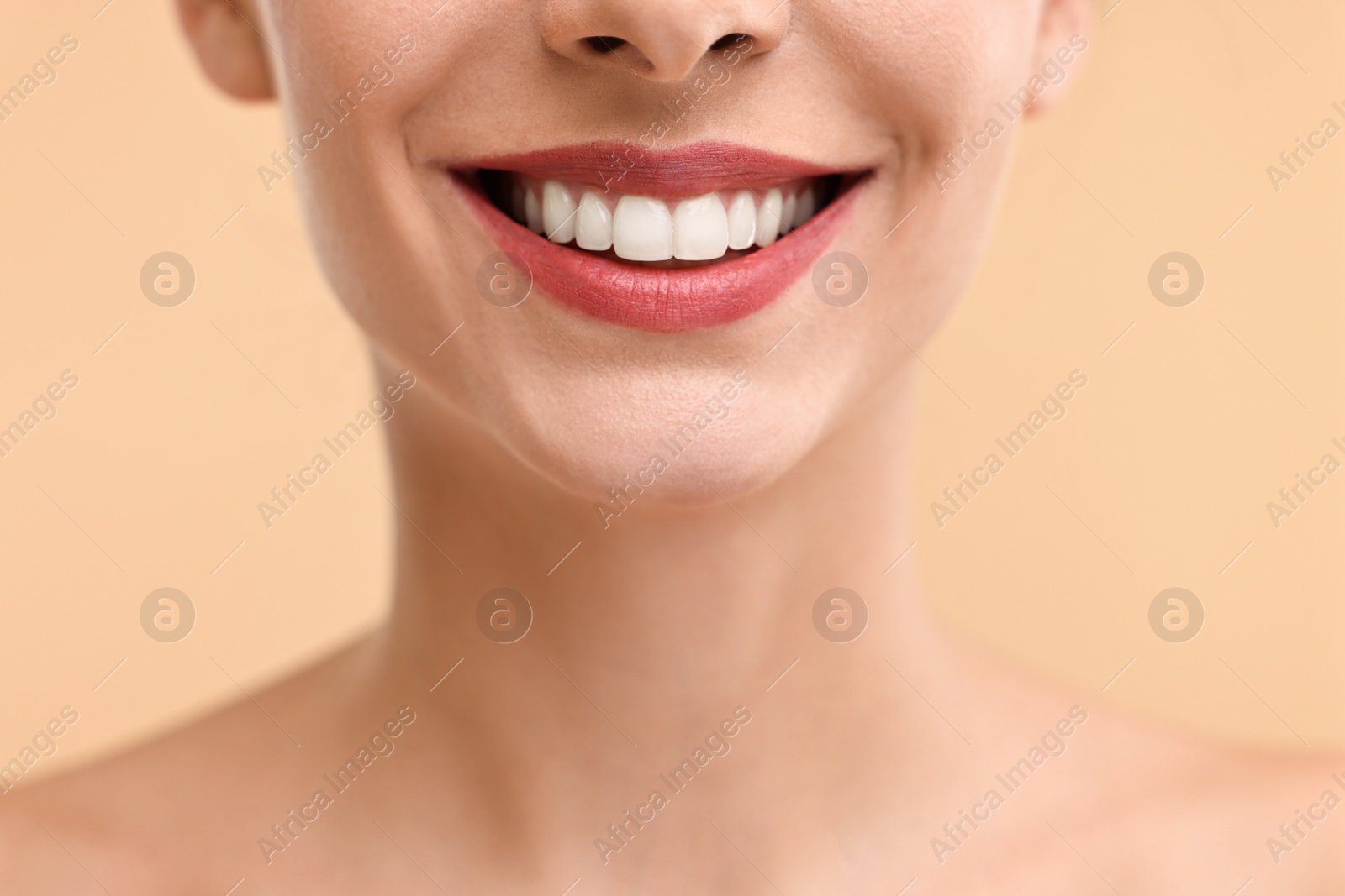 Photo of Woman with beautiful lips smiling on beige background, closeup