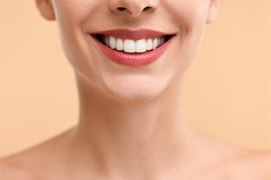 Photo of Woman with beautiful lips smiling on beige background, closeup