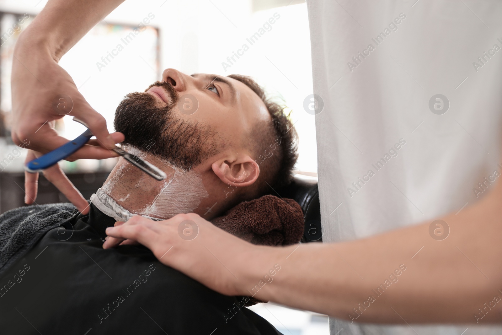 Photo of Professional barber working with client in hairdressing salon. Hipster fashion