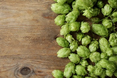 Photo of Fresh green hops on wooden table, top view. Space for text