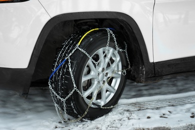 Car with snow chain on tire, closeup. Winter season