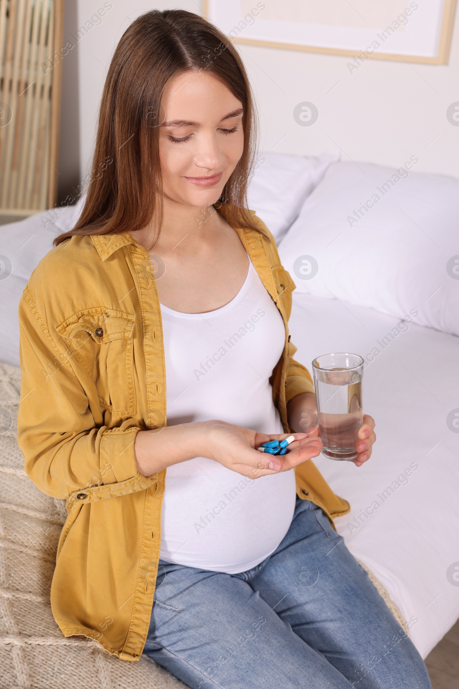 Photo of Beautiful pregnant woman taking pills at home