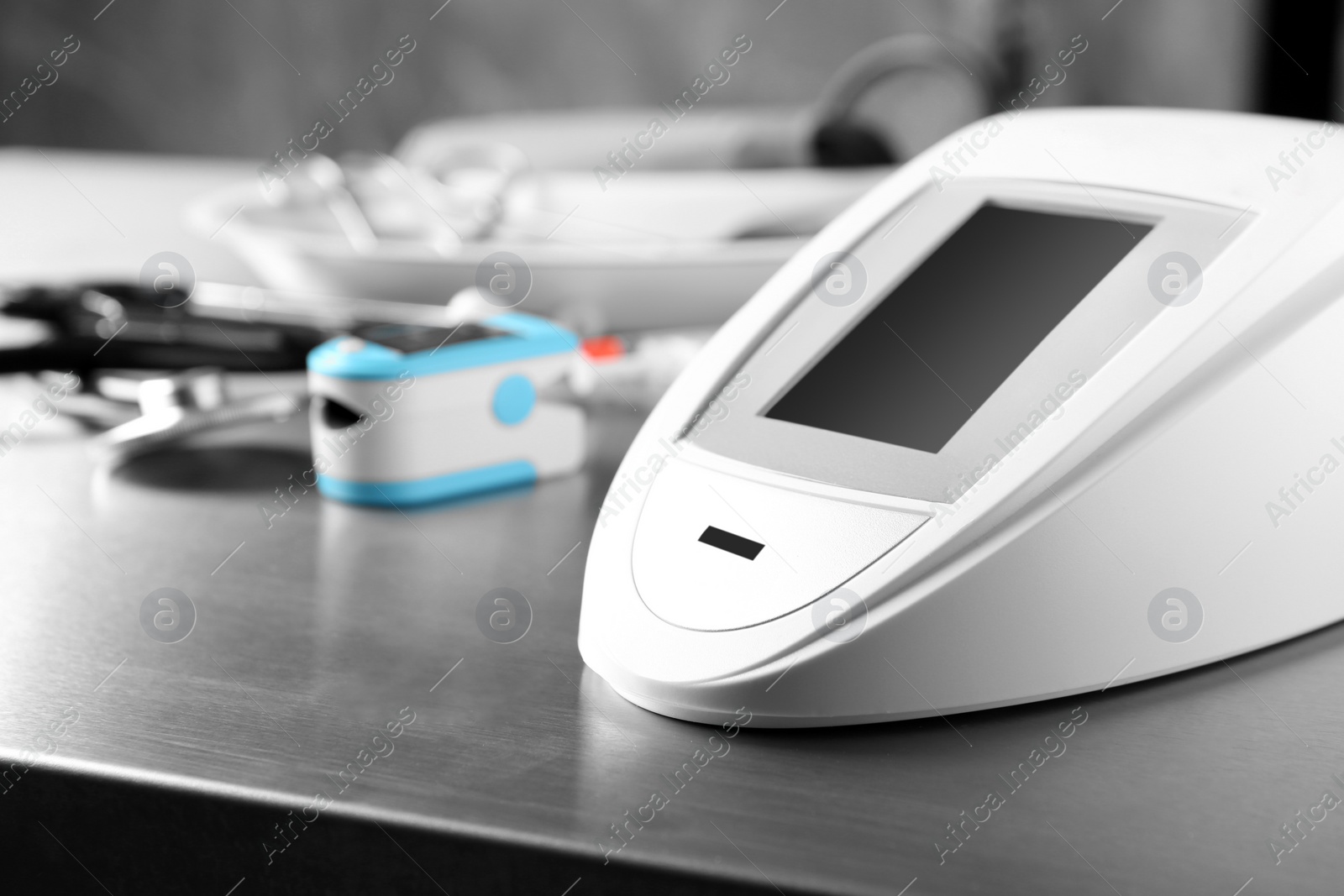 Photo of Sphygmomanometer and other medical objects on grey table. Space for text