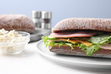 Photo of Tasty sandwich with ham on white wooden table, closeup