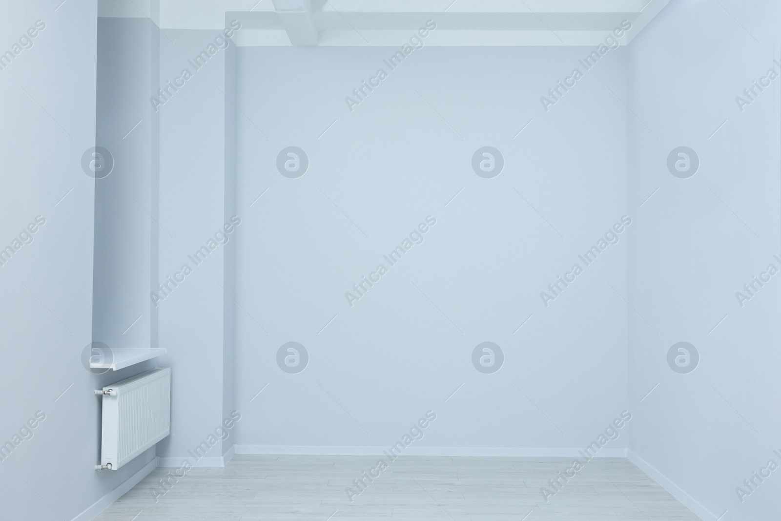 Photo of Empty room with white walls, heater and sockets during repair