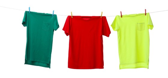 Photo of Colorful t-shirts drying on washing line isolated on white