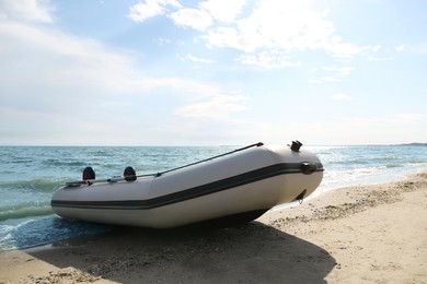 Inflatable rubber fishing boat on sandy beach near sea