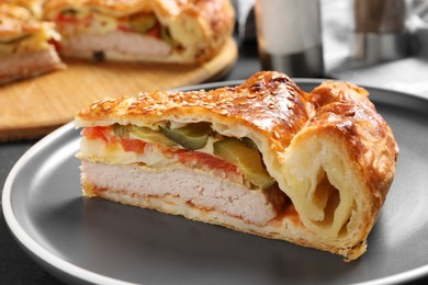 Photo of Piece of tasty homemade pie with filling on dark grey table, closeup