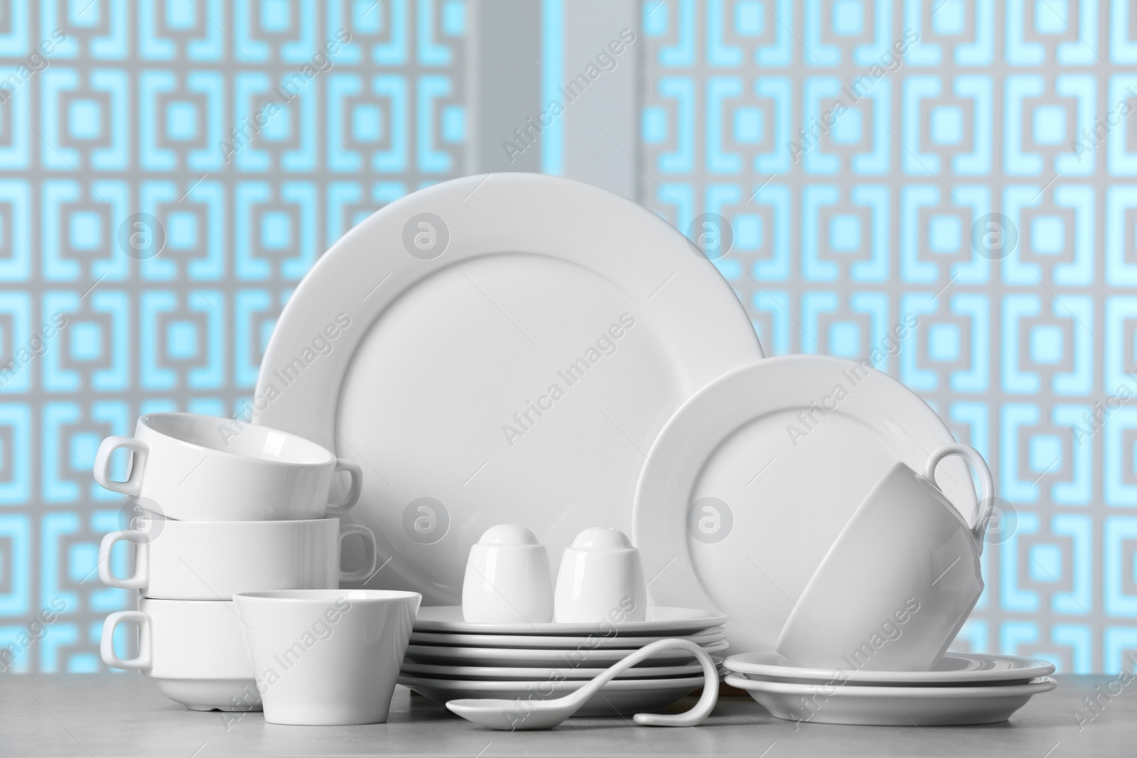 Photo of Set of clean dishware on light grey table