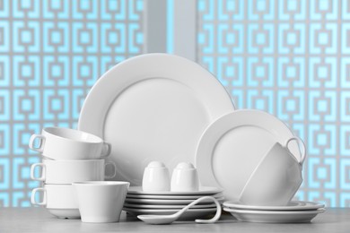 Set of clean dishware on light grey table