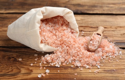 Overturned sack of pink himalayan salt on wooden table