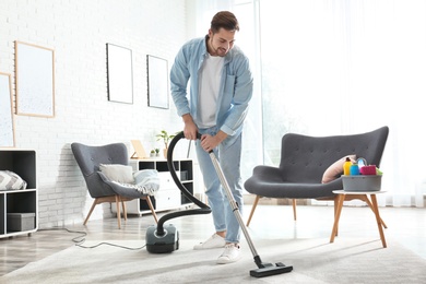 Photo of Portrait of janitor with vacuum cleaner in living room