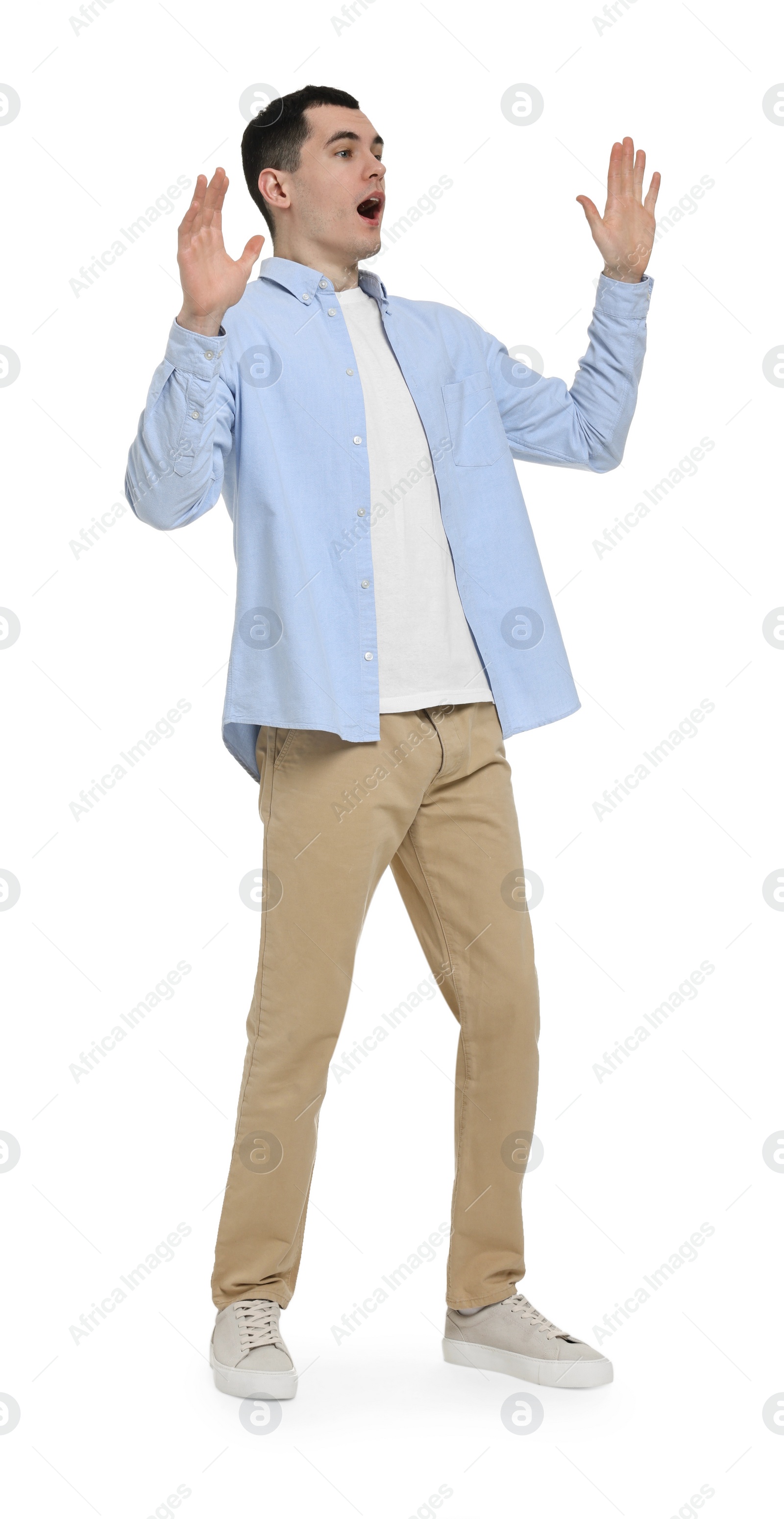 Photo of Shocked man in light blue shirt and beige pants on white background