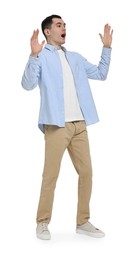 Photo of Shocked man in light blue shirt and beige pants on white background