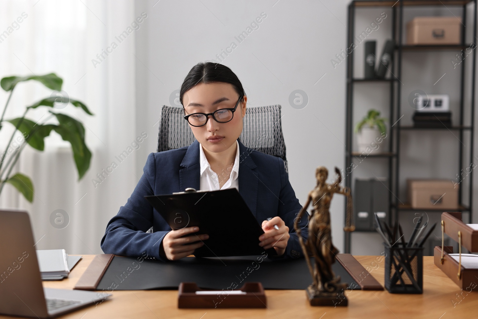 Photo of Notary reading document at table in office