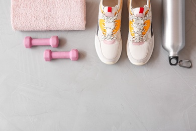 Photo of Flat lay composition with fitness equipment and space for text on gray background