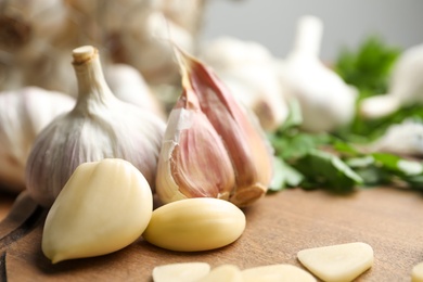 Photo of Fresh garlic bulb and cloves on wooden table, closeup. Organic product