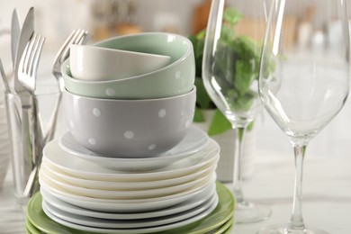 Photo of Many different clean dishware, glasses and cutlery on table indoors, closeup