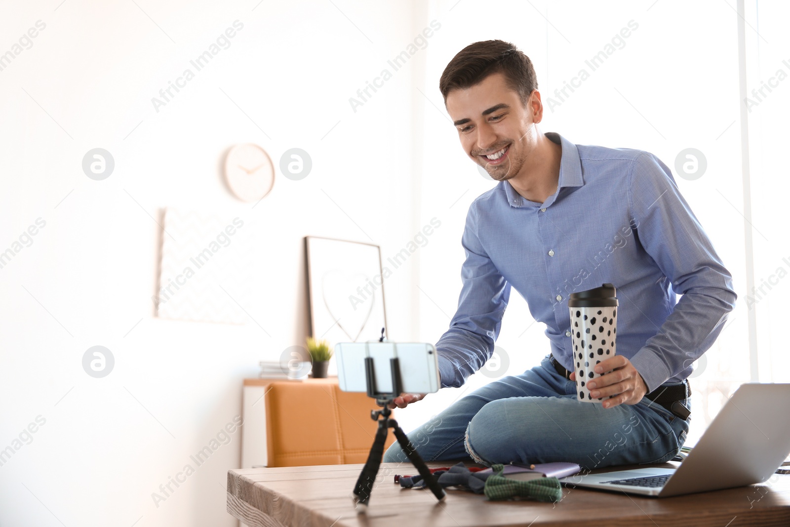 Photo of Young blogger recording video at table