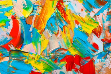 Closeup view of artist's palette with mixed bright paints as background