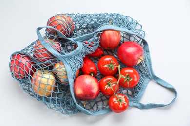 String bag with vegetables and apples on light grey background, top view