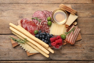 Photo of Snack set with delicious Parmesan cheese on wooden table, top view