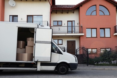 Photo of Van full of moving boxes near new house