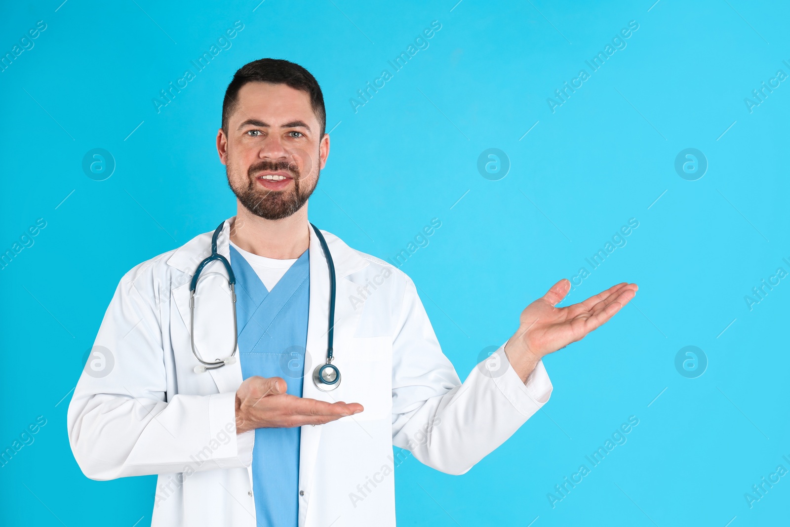 Photo of Mature doctor with stethoscope on blue background