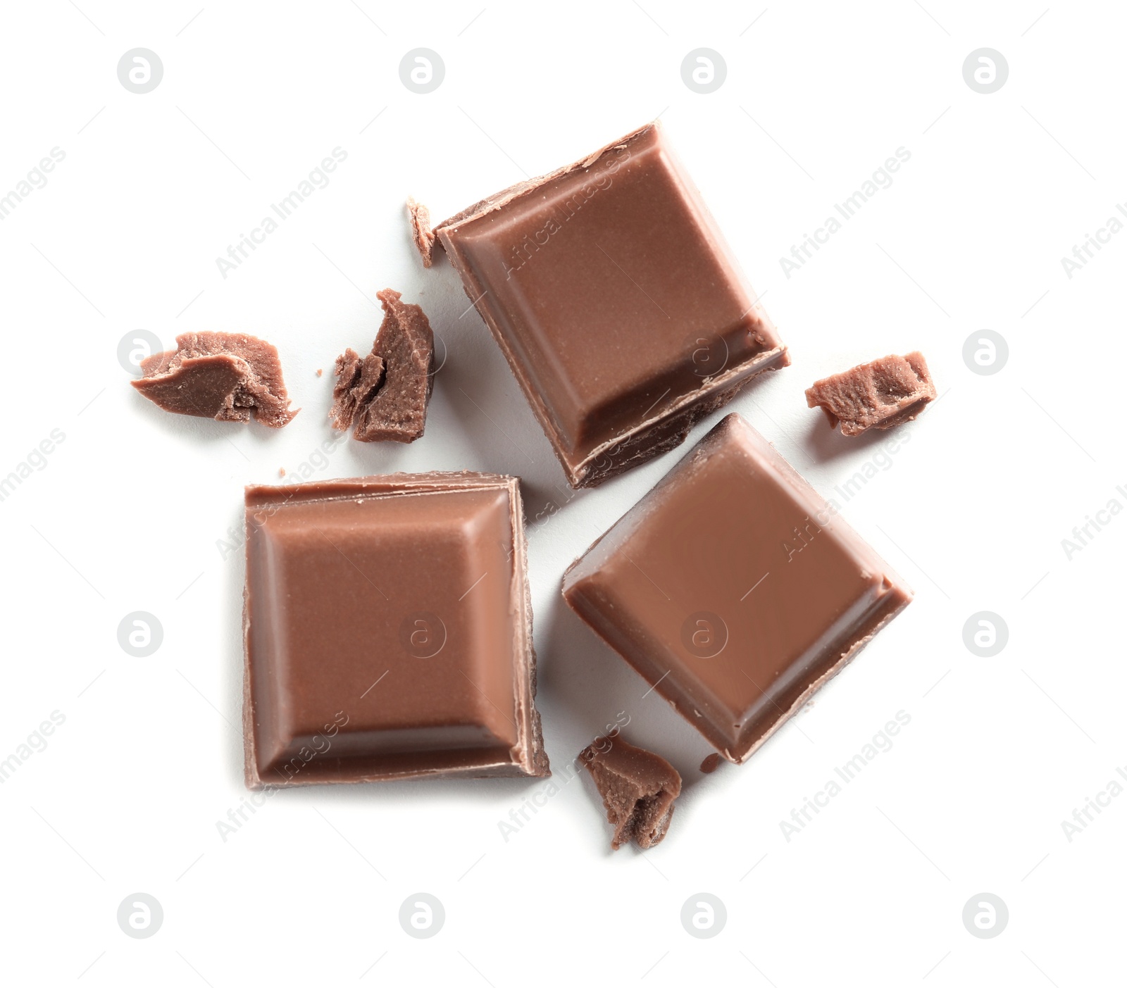 Photo of Pieces of tasty milk chocolate on white background, top view