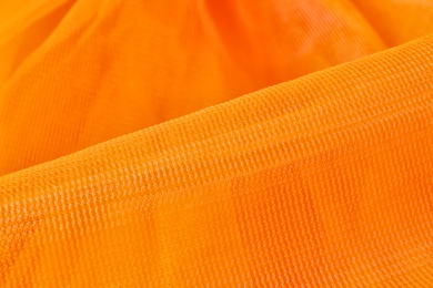 Texture of orange tulle as background, closeup