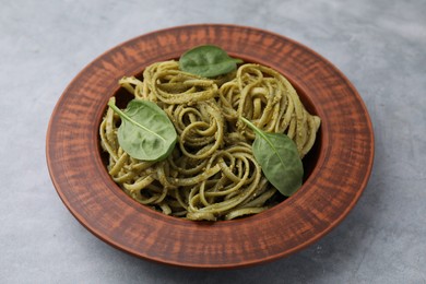 Photo of Tasty pasta with spinach on grey table, closeup