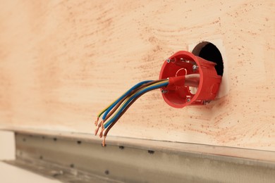 Photo of Mounting box with wires on wall, closeup. Space for text