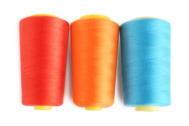 Photo of Colorful sewing threads on white background, top view